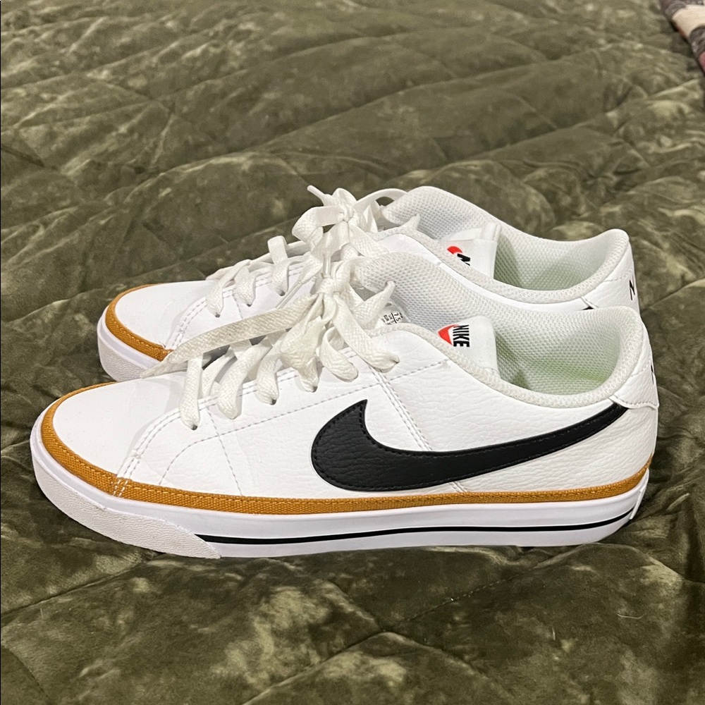 Nike White Low-Top Sneakers with Black Swoosh and Gold Accent